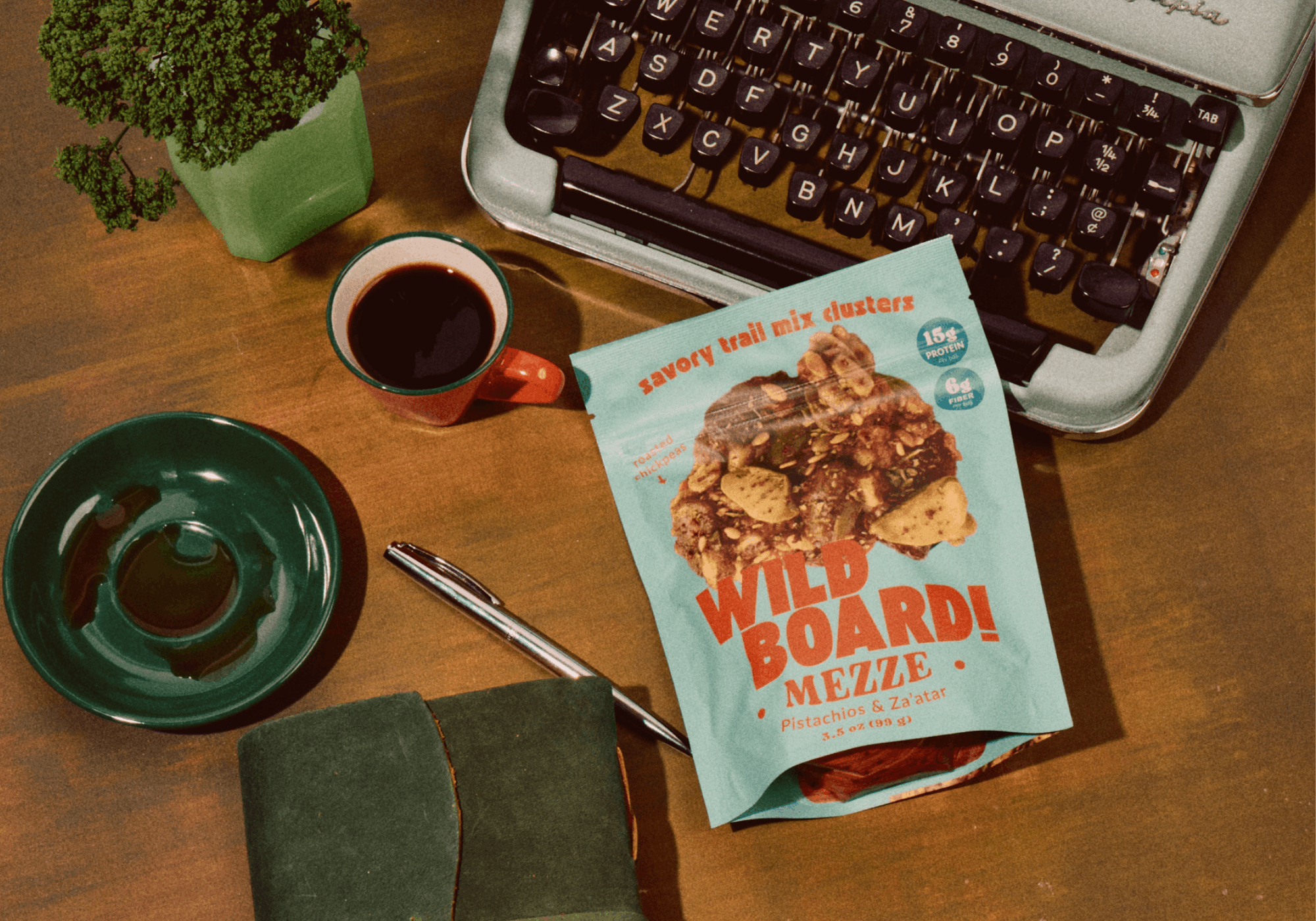 A bag of WildBoard savory trail mix clusters open on a desk, the mid-afternoon snack that will not crumb a keyboard